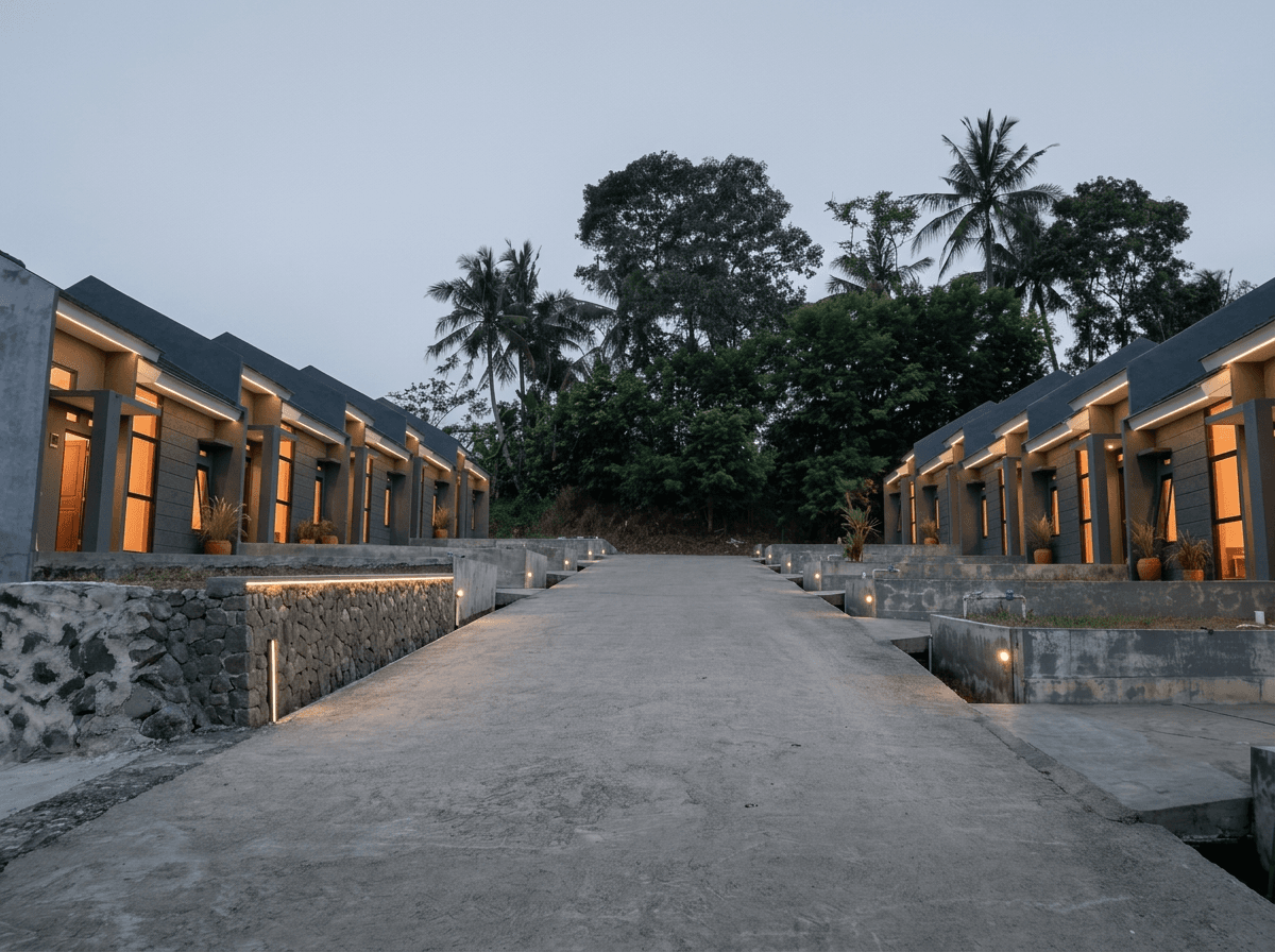 Jalan di dalam kawasan New Grand Puri Laras saat senja, dengan deret rumah di kedua sisi dan pepohonan di ujung jalan